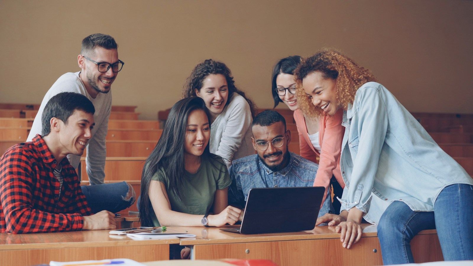 A group of students working together around a laptop