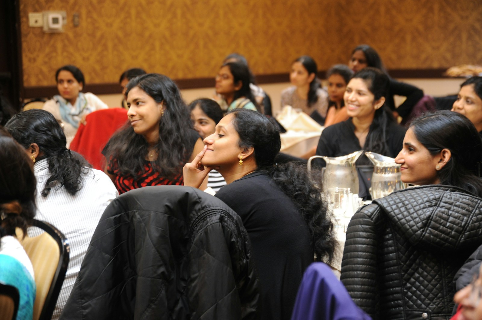 Women seated in an audience listening to a discussion